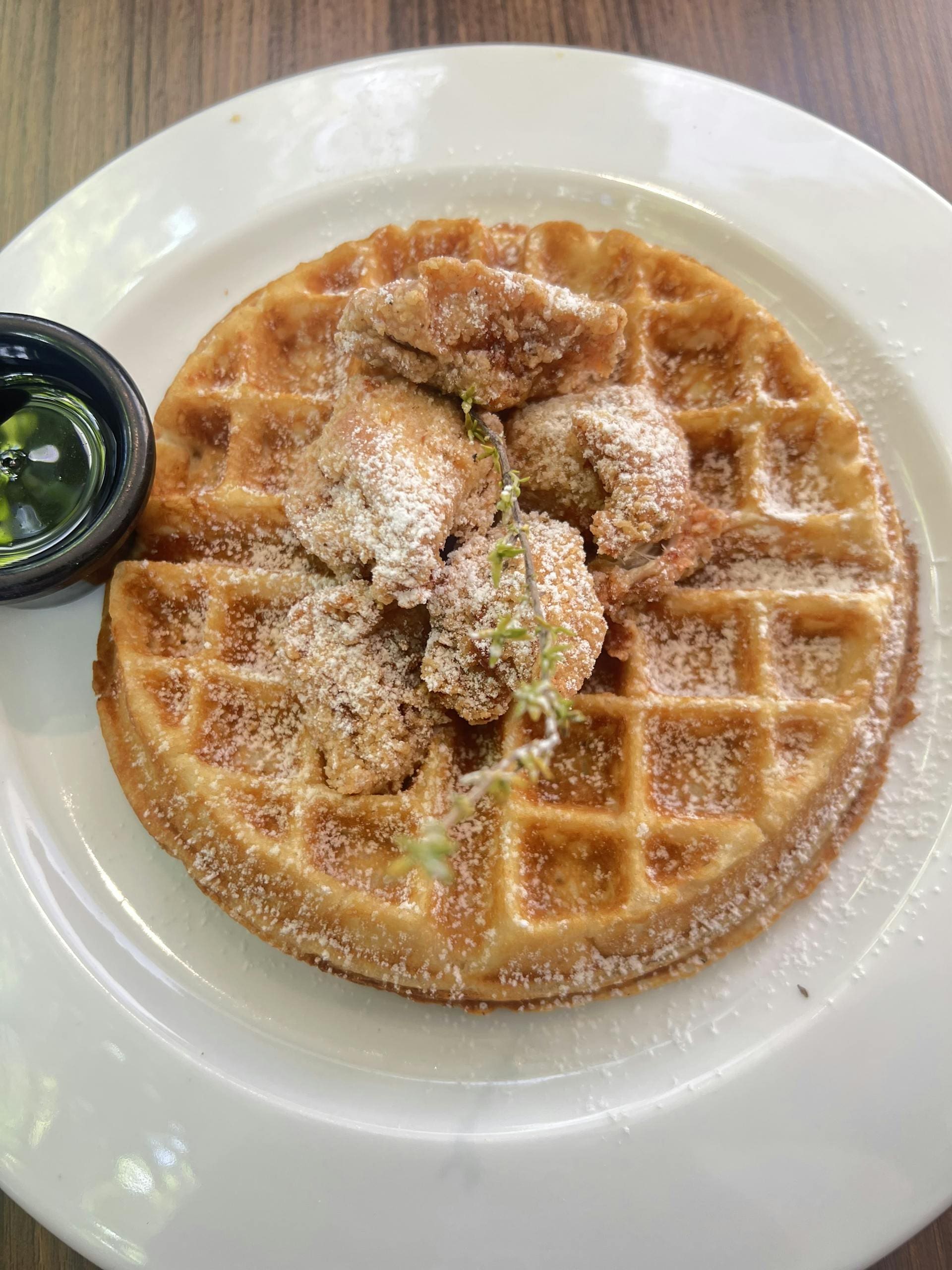 Delicious crispy chicken on golden waffle served with syrup, perfect for brunch.