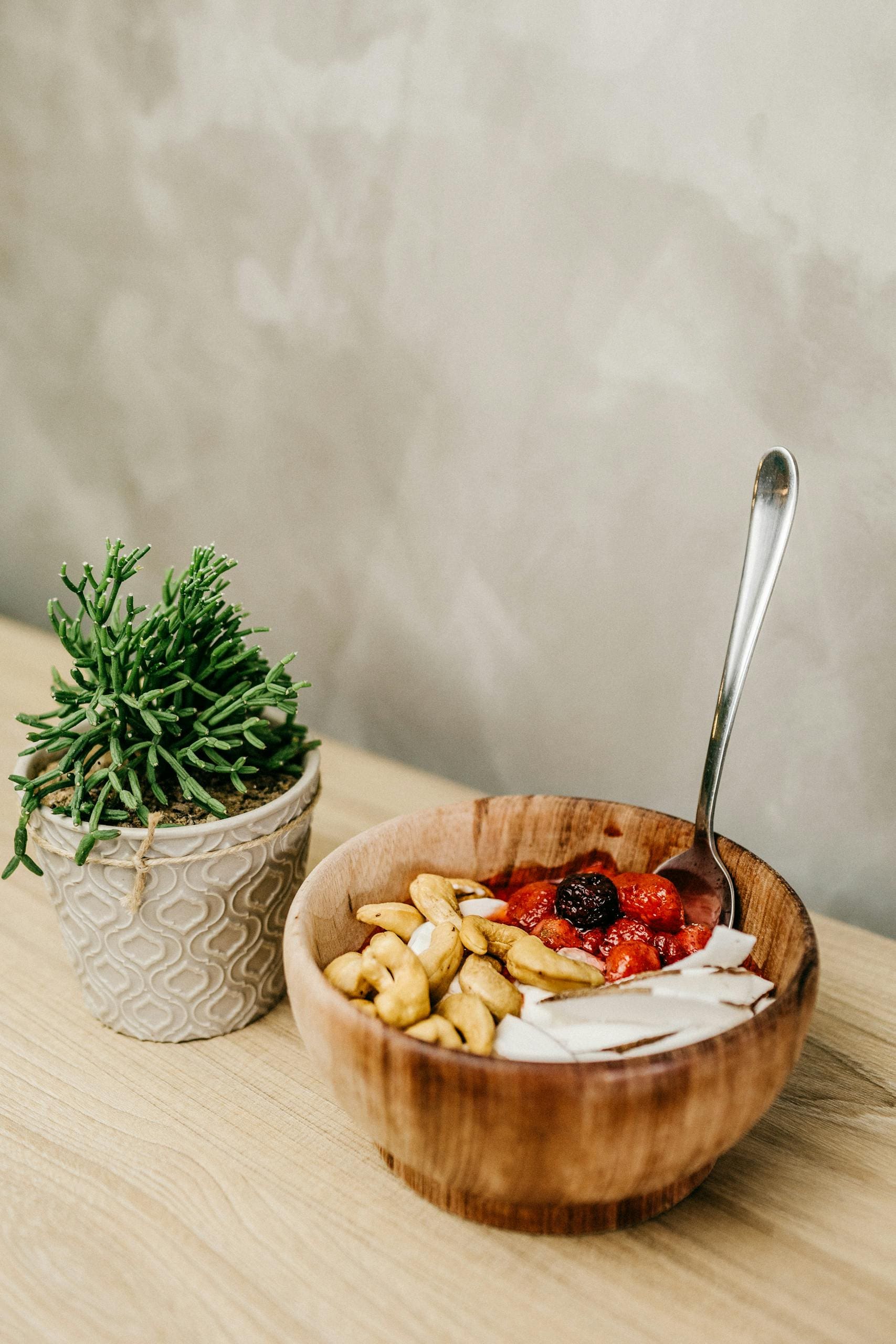 Delicious homemade acai bowl with cashews and fresh berries in a wooden bowl, promoting a healthy diet.