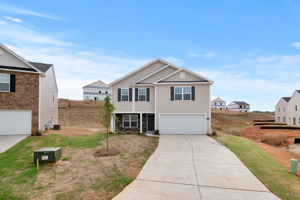 Newly constructed suburban home with spacious driveway and developing neighborhood.